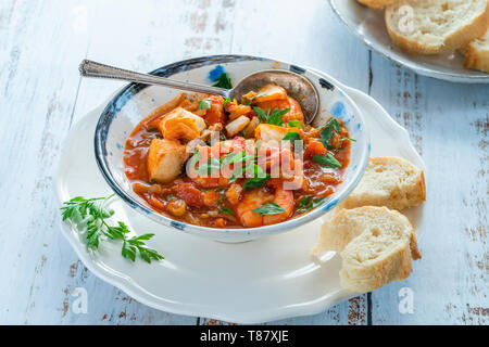 Tiger Garnelen und Fisch Eintopf in eine Schüssel geben. Stockfoto