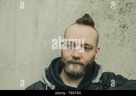 Denken bärtiger Mann nach unten vor einer Wand Stockfoto