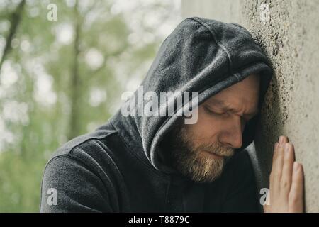 Mann traurig seinen Kopf gegen eine Wand gelehnt Stockfoto