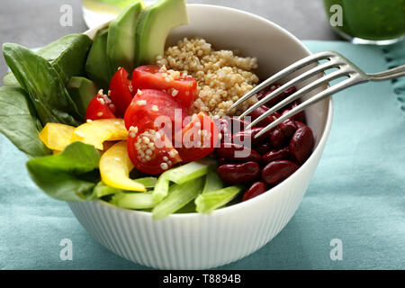 Schüssel mit leckerem Quinoa Salat auf Tisch, Nahaufnahme Stockfoto