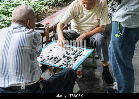 Chengdu, Sichuan, China - 21.09.2017: Ältere chinesische Männer spielen gehen, eine chinesische Brettspiel, in Völker's Park in Chengdu Stockfoto