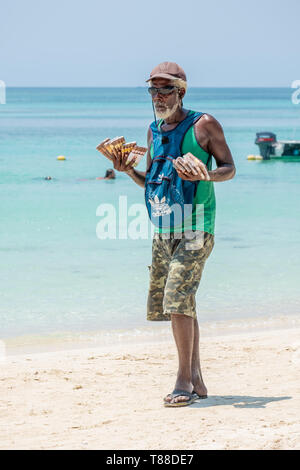 Lokaler Mann in West Bay Roatan Honduras verkauft Zigarren zu Touristen am Strand. Stockfoto