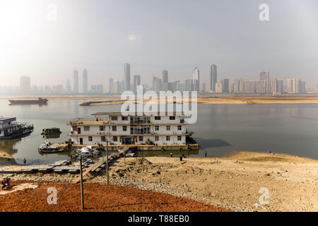 Die Schiffe auf dem Fluss Gan, im Hintergrund das Finanzviertel von Nanchang, China. Stockfoto