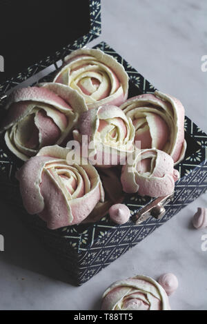 Rosa Baisers, wie Rosen geprägt. In einer Blue Box, Romantische appetitlich Baisers zum Valentinstag. Stockfoto