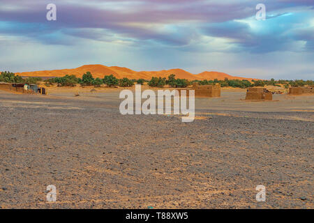 Schwarz verlassenen Wüste in der Nähe von Erg Chebbi Merzouga Sahara, auf dem Hintergrund einer Sanddüne und ein altes Dorf, Marokko in Afrika Stockfoto