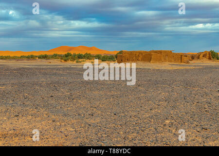 Schwarz verlassenen Wüste in der Nähe von Erg Chebbi Merzouga Sahara, auf dem Hintergrund einer Sanddüne und ein altes Dorf, Marokko in Afrika Stockfoto