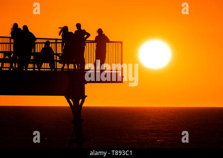 Aberystwyth Wales UK, Samstag, 11. Mai 2019 Deutschland Wetter: Menschen sind gegen den herrlichen Sonnenuntergang Silhouette, wie Sie auf dem Pier in Aberystwyth auf der Cardigan Bay Küste stehen, West Wales. Das Wetter soll in der kommenden Woche wieder wärmer als Zeit der unruhigen kalten Bedingungen zu erhalten. Photo credit Keith Morris/Alamy leben Nachrichten Stockfoto