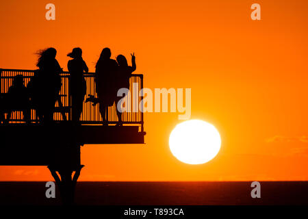 Aberystwyth Wales UK, Samstag, 11. Mai 2019 Deutschland Wetter: Menschen sind gegen den herrlichen Sonnenuntergang Silhouette, wie Sie auf dem Pier in Aberystwyth auf der Cardigan Bay Küste stehen, West Wales. Das Wetter soll in der kommenden Woche wieder wärmer als Zeit der unruhigen kalten Bedingungen zu erhalten. Photo credit Keith Morris/Alamy leben Nachrichten Stockfoto