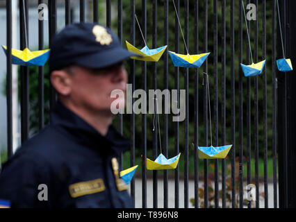 Papier Schiffe in der Ukrainischen nationalen Flagge Farben bemalt werden gesehen, hängend an einem Zaun von der Russischen Botschaft in den Protest. Die Aktivisten protestieren gegen Amnestie für Russland unterstützten Separatisten im Osten des Landes und auch die Nachfrage der Ukrainische Gesetzgeber für das zu stimmen? 9438 Gesetzentwurf über internationale Verbrechen. Stockfoto