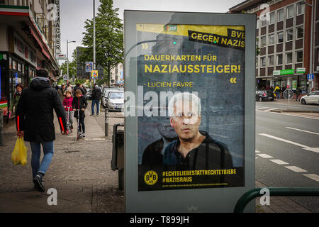 11. Mai 2019, Nordrhein-Westfalen, Dortmund: Ein illegal aufgehängt Poster mit einem Foto der Trainer von Borussia Dortmund, Lucien Favre, und eason Tickets der Beschriftung für die NS-drop-outs" kann auf dem Weg zum Stadion gesehen werden. Unbekannte Personen hatte aufgelegt Poster mit teilweise drastischen Bekenntnisse gegen Nazis in der Werbung präsentiert an mehreren Standorten, die Spieler und die Trainer von Borussia Dortmund zugeschrieben wurden. Foto: Stephan Schütze/dpa - ACHTUNG: Nur für redaktionelle Nutzung in Verbindung mit der aktuellen Berichterstattung über die plakatkampagne und nur mit vollständiger Nennung des oben cr Stockfoto