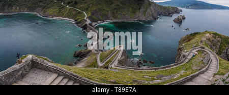 An der Küste von San Juan de Gaztelugatxe, Dragon-Stein im Spiel der Throne, die Brücke und die Steintreppe. Gelbe Blüten im Frühjahr und Sommer Stockfoto