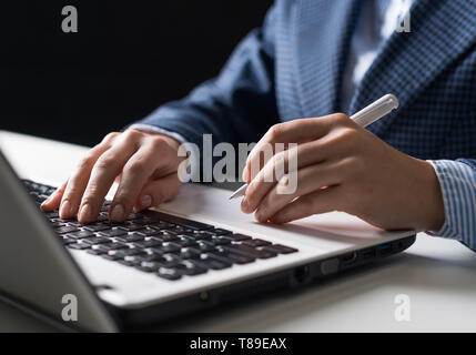 Mann im Anzug am Schreibtisch sitzt mit Laptop Stockfoto