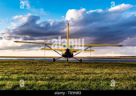 Swift Current, SK/Kanada - 10. Mai 2019: Gelb Cessna Flugzeug in stürmischen Himmel gebunden Stockfoto