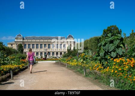 Frankreich, Paris, Jardin des Plantes, Walker auf einem Pfad mit der Grande Galerie de l'Evolution im Hintergrund Stockfoto