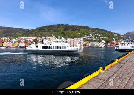 Lokale Fahrgast Katamaran Teisten in Strandkaien Anschlußklemme n Hafen von Bergen, Norwegen anreisen. Hanseatic Bryggen im Hintergrund. Stockfoto