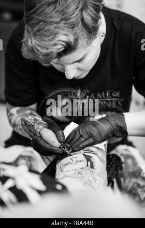 Tattoo Artist Alíz Andorka bei der Arbeit Stockfoto