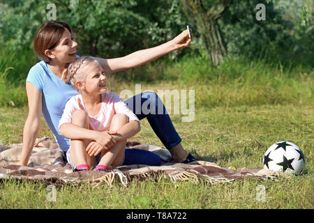 Mutter und ihre kleine Tochter unter selfie in Park Stockfoto