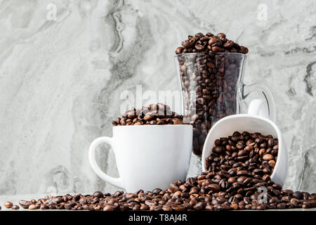 In Tasse schwarzen Kaffee und Kaffeebohnen auf Marmor Hintergrund. Ansicht von oben, Platz für Text Stockfoto