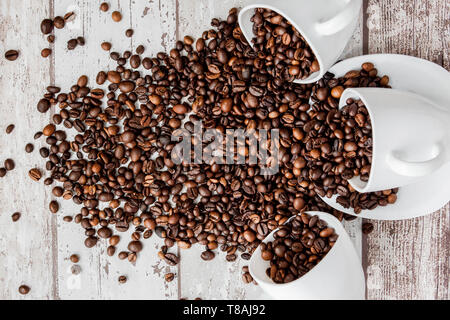 In weiße Tasse schwarzen Kaffee und Kaffeebohnen auf hellen Hintergrund. Ansicht von oben, Platz für Text Stockfoto