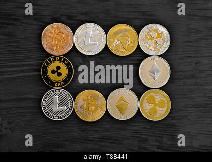 Münzen von kryptografischen Währung auf einem schwarzen Holz- Hintergrund bilden ein Rechteck Frame: bitcoin, litecoin, Wellen. Für Text platzieren. Stockfoto