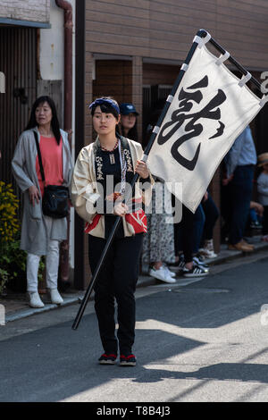 Volks, Japan - Mai 5, 2019: Junge Dame in traditionellen Kostümen Parade durch die Straße mit einem Flag neue imperiale Ära zu feiern sind Iwa' Stockfoto