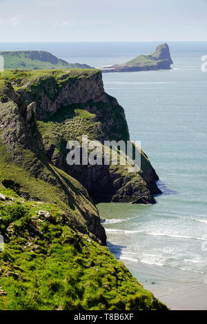 Blick entlang der Klippen am Rhossili Bay mit den Gezeiten Insel Würmer Kopf in der Ferne. Stockfoto