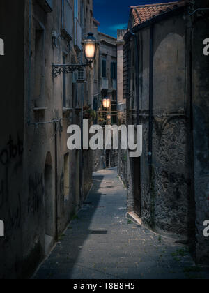 Straßen von Tropea in Italien in dunkler Nacht oder am Abend. Helle Laternen leuchten die alte buildnings und engen Wege. Stockfoto