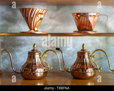 Vintage Kupfer hand Tropfen Kaffee Wasserkocher mit Vintage Kupfer/Tropfer auf Holztisch auf Zement Hintergrund. Stockfoto