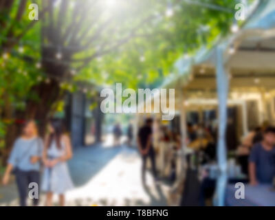 Abstrakte verschwommen Menschen zu Fuß auf Flohmarkt Hintergrund mit Sonnenlicht. Stockfoto