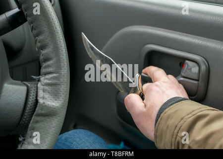 Blick auf das Messer in der Hand der Fahrer im Auto, die Tür zu öffnen Stockfoto