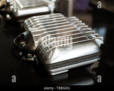 - Aus der Nähe moderne Silber Electric Sandwich maker Maschine auf dunklem Hintergrund. Stockfoto