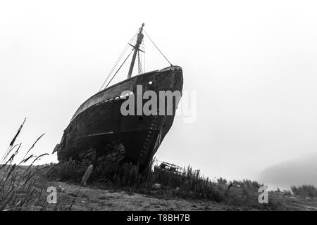 Alte Schiffswracks im Morgennebel. Schwarz/Weiß-Bild Stockfoto