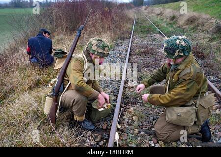 Frankreich, Eure, Cocherel, Allied Rekonstitution Group (USA Weltkrieg 2 und der französischen Maquis historische Rekonstruktion Association), reenactors, die die Rolle der britischen Soldaten Vorbereiten einer Eisenbahnschiene zu sabotieren, mit einem Kunststoff explosive Laib unter der Wachsamkeit der Partisanen der französischen Streitkräfte Innenraum (FFI) Stockfoto