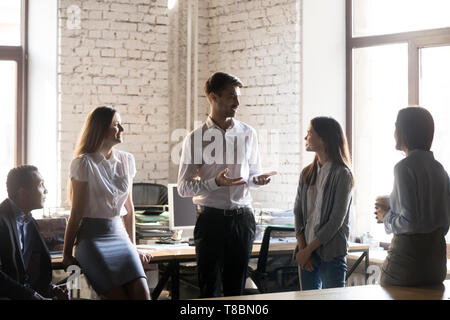 Diverse Mitarbeiter versammeln sich im Büro hören team leader Stockfoto