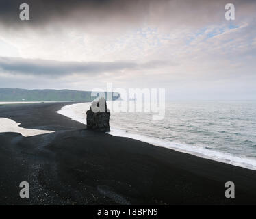 Blick vom Kap Dyrholaey auf Stapel Arnardrangur und Reynisdrangar Basalt sea Stacks. Reynisfjara Strand mit schwarzem Sand vulkanischen Ursprungs. Touristenattraktion in Stockfoto