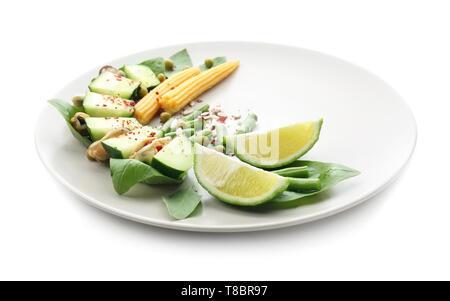 Lecker Salat mit Muscheln und Gemüse auf Platte gegen den weißen Hintergrund Stockfoto