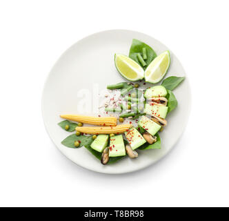 Lecker Salat mit Muscheln und Gemüse auf Platte gegen den weißen Hintergrund Stockfoto