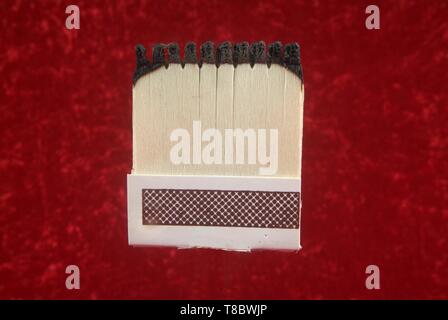 Burnout bei der Arbeit und über erschöpft Konzept. Leitung der Spiele und alle verbrannt. Mit rotem Hintergrund. Stockfoto