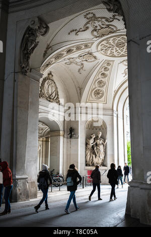 Ansicht der Rückseite des Touristen zu Fuß durch St. Michael's Gate (Michaelertrakt) - Der Haupteingang der Hofburg in Wien, Österreich. Stockfoto