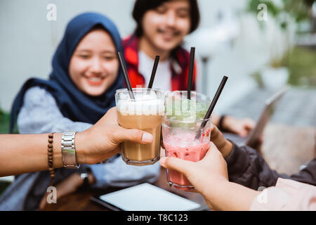 Muslimische Frau mit Freund toast Ihr Getränk Stockfoto