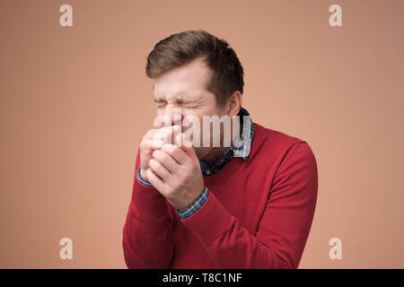 Schöne reife Manin rot pullover viel zu husten. Stockfoto