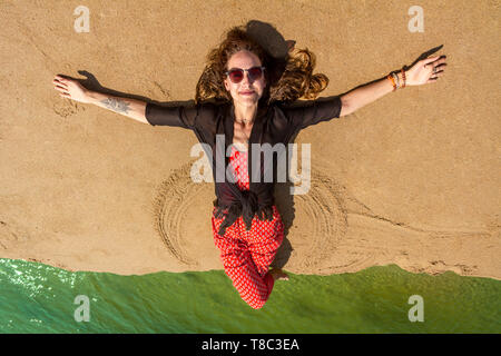 Junge kaukasier Frau genießen, Strand, Liegen und bis suchen, Areal shot mit Drone. Stockfoto