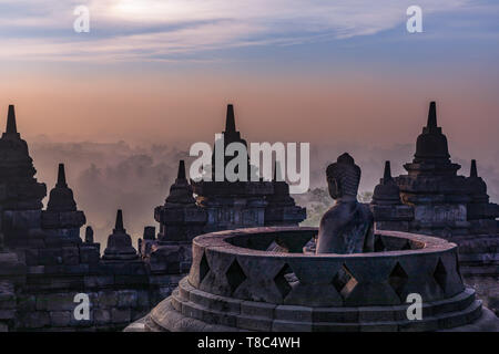 Buddha Statue bei Sonnenaufgang, Borobudur Tempel Komplex, Borobudur, Yogyakarta, Java, Indonesien Stockfoto