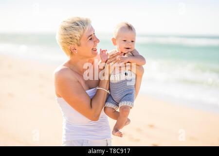 Attraktive Blondine Mutter mit 4 Monate alten Baby auf den Strand, Portugal Stockfoto