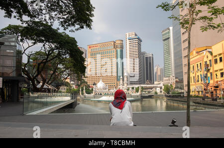Ansicht der Rückseite Frau gegen Jamek Moschee in Kuala Lumpur, Malaysia sitzen Stockfoto