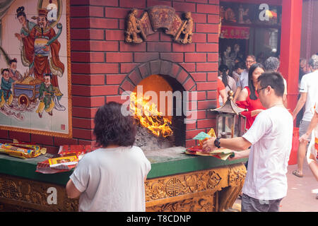 Der Traditionellen Chinesischen neue Jahr Ritual des Verbrennens von Replik Papiergeld und Joss Papier, Chinesischen Gottesdienst in einem Tempel, Kuala Lumpur, Malaysia Stockfoto