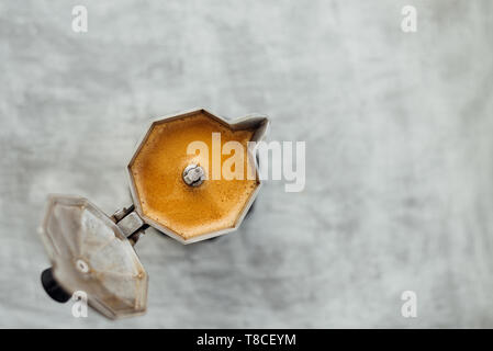 Moka Topf mit frisch gebrühtem Kaffee auf grauem Hintergrund Stockfoto