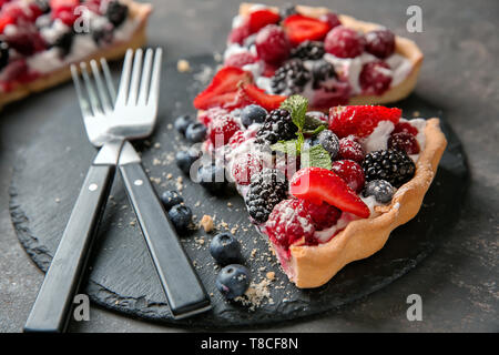 Schiefer Teller mit leckeren Berry pie auf Tisch Stockfoto