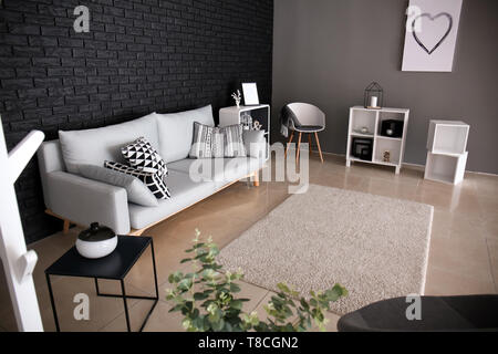 Innenraum der Wohnzimmer mit stilvollen komfortablen Sofa in der Nähe der schwarzen Wand Stockfoto