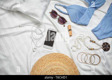 Komposition mit Badebekleidung und Zubehör auf Bettwäsche Stockfoto